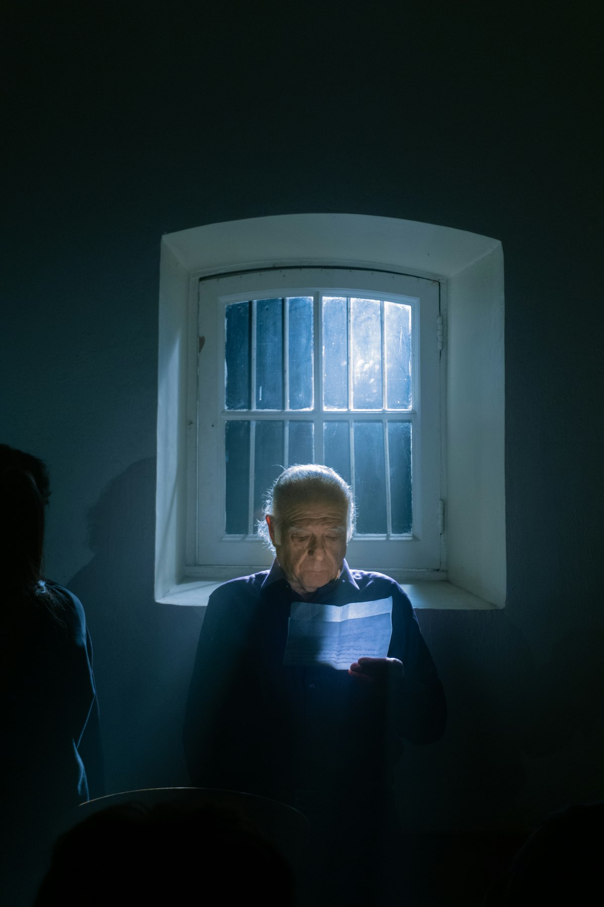 A man sitting by a window in a quiet room